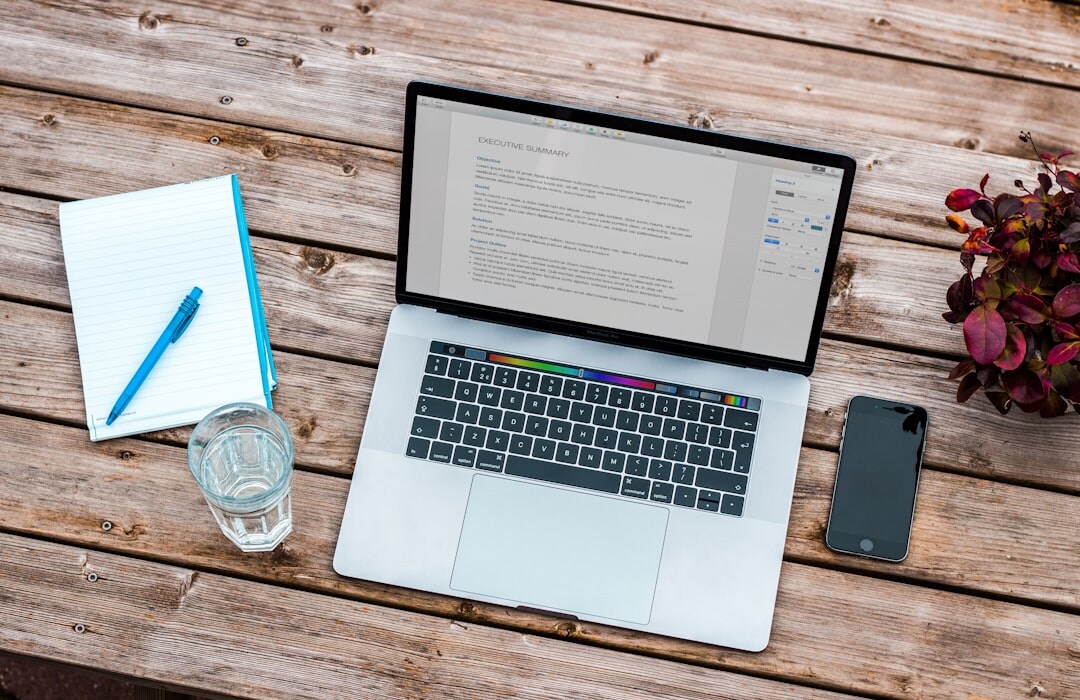 Overhead view of a desk with laptop, notebook and coffee