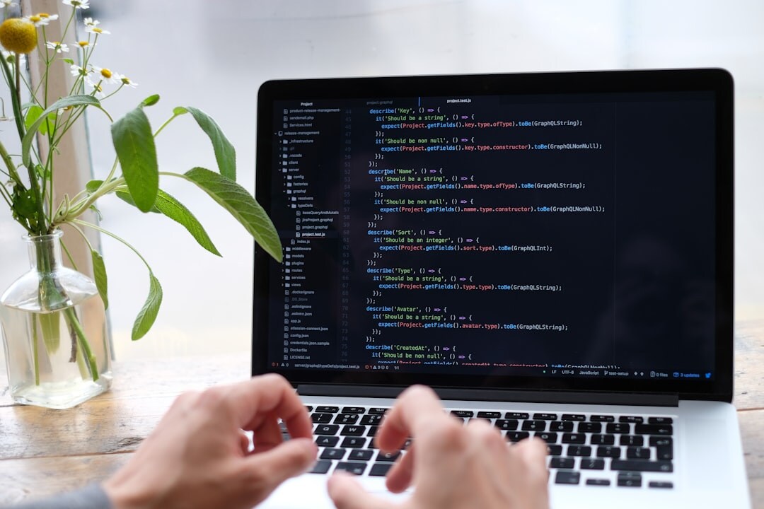 Person typing on a laptop with lines of code visible