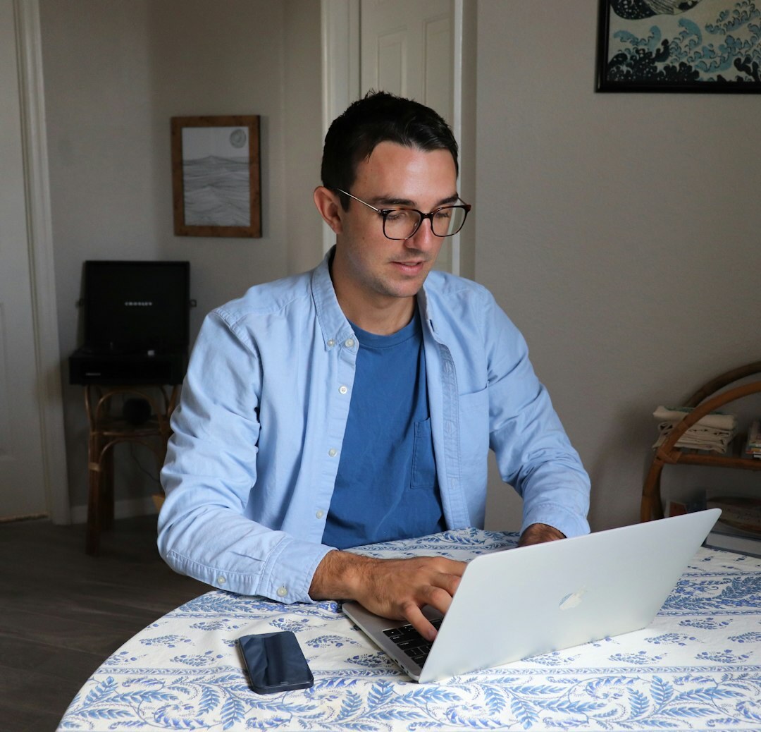 Portuguese software developer working on a laptop at a desk